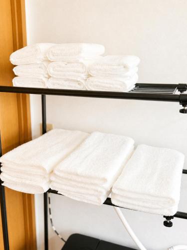 a couple of shelves filled with white towels at Glad Kasuga in Kasugabaru
