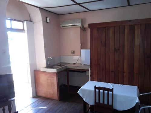 Hotel Valiha في دييجو سواريز: مطبخ مع حوض وطاولة في الغرفة