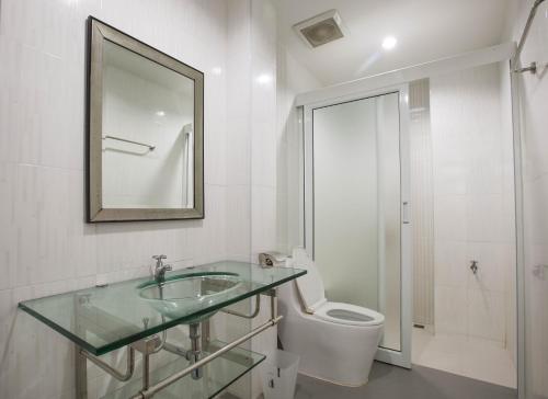 a bathroom with a sink and a toilet and a mirror at 217@HKT in Phuket
