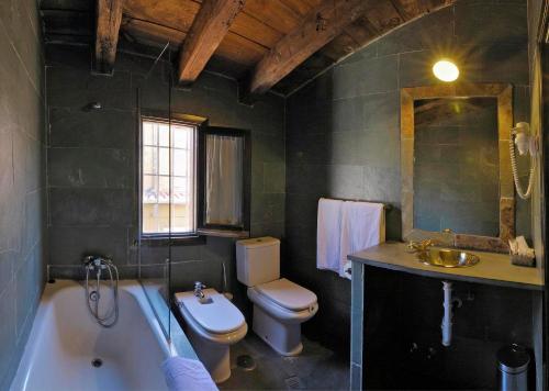 a bathroom with a tub and a toilet and a sink at Apartamentos El Tiempo Madrid in Madrid