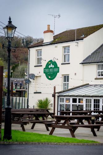 a wooden picnic table in front of a white building at The Belfry, Littldean in Little Dean