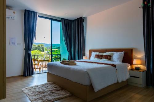a bedroom with a large bed and a balcony at Ck Home Lanta in Phra Ae beach