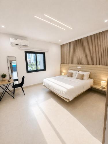 a bedroom with a bed and a desk and a chair at Appartement Palms Abidjan in Abidjan