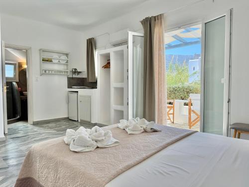 a bedroom with a large bed with towels on it at Magginas Studios in Parikia