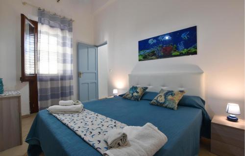 a bedroom with a blue bed with towels on it at 1 Bedroom Beautiful Apartment In Trappeto in Trappeto