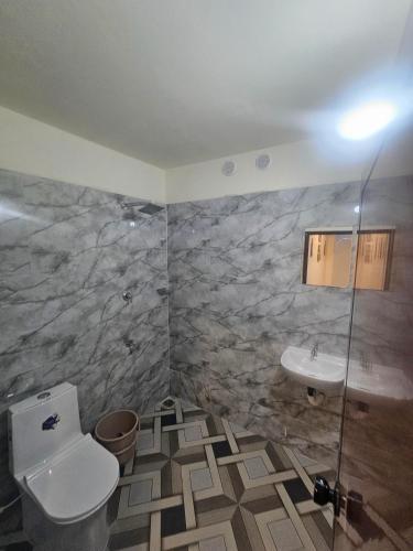 a bathroom with a toilet and a sink at Richard's Homestay -Classy AC Rooms in Thiruvalla
