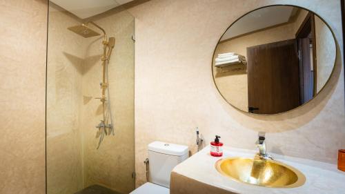 a bathroom with a gold sink and a mirror at Bhalil Farm House in Sefrou