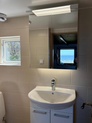 a bathroom with a sink and a mirror at The Small Beach House in Rydebäck