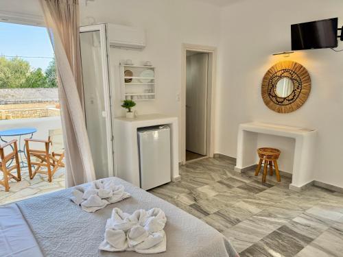 a bedroom with a bed and a table and a balcony at Magginas Studios in Parikia