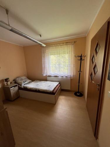 a bedroom with a bed and a window at Holiday house EWA in Meszna Opacka