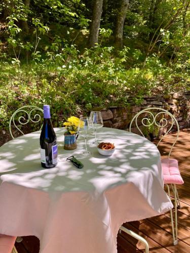 a table with a bottle of wine and glasses at Le printemps, gîte nature in Bruyères