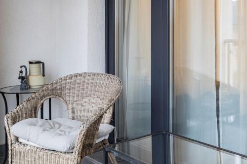 a wicker chair sitting on a balcony with a table at Modern 2BR Balcony View Pipera in Voluntari