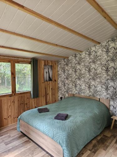 a bedroom with a bed with a green comforter at Chalet La Savane in Le Gond