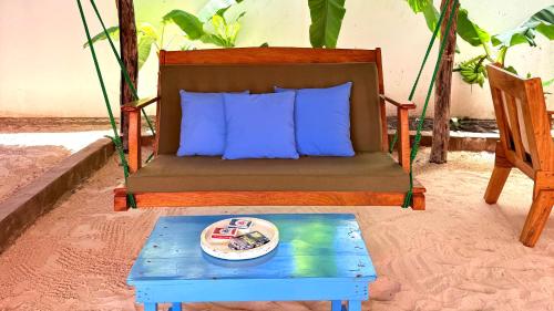 a bed and a table with a plate of food on it at The 5th Element Boutique Hotel in Paje