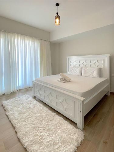 a white bedroom with a large white bed with a white rug at Nyali Evoque - BriSta Stays in Mombasa