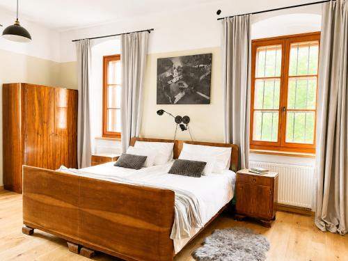 a bedroom with a large bed with white sheets at Rezidenca Korman in Fala