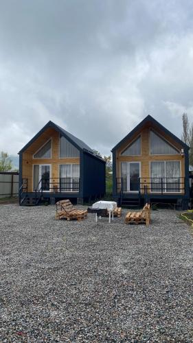 a couple of buildings with benches in front of them at Barn Peaks Karakol in Karakol
