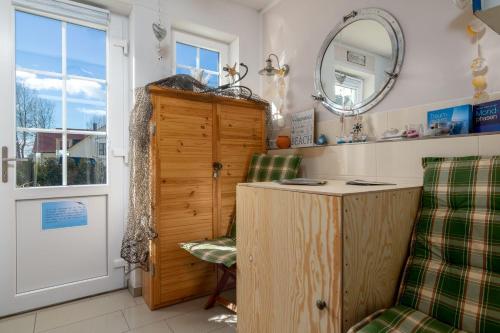a room with a table and two chairs and a mirror at Strandhaus zum Lotsenturm in Thiessow