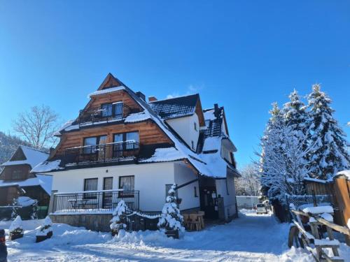 a house covered in snow in the mountains at Willa Przy Skoczni in Zakopane