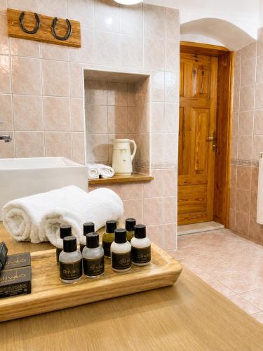 a wooden tray with four bottles of essential oils in a bathroom at Rezidenca Korman in Fala