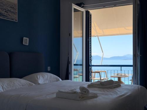 a bedroom with a bed with a view of the ocean at Hotel Avra in Egina