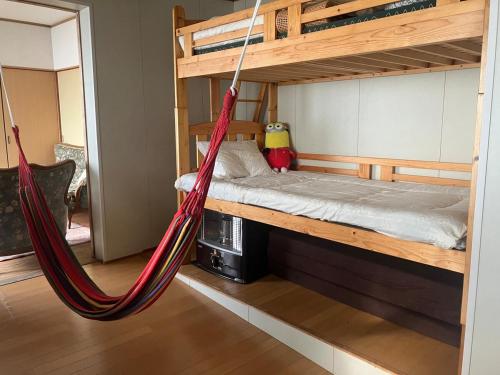 a hammock in a room with a bunk bed at HOTEL OK GREEN TEA -Condo with ocean view- in Sonogi