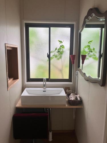 a bathroom with a sink and a window at HOTEL OK GREEN TEA -Condo with ocean view- in Sonogi