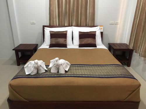 a bedroom with a bed with two towels on it at Jim Guesthouse in Kanchanaburi City