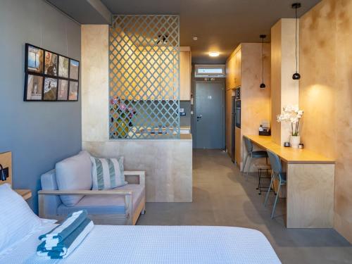 a bedroom with a bed and a desk and a kitchen at Downtown photographer's studio 2 in Korinthos