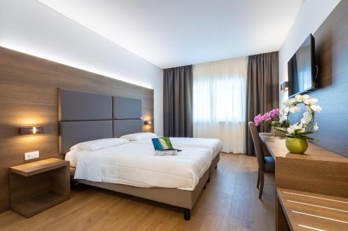 a hotel room with a bed and a desk at Park Hotel Gemona in Gemona del Friuli