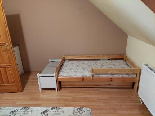 a bedroom with a bunk bed in the attic at Szikszai Apartman in Balatonfůzfő