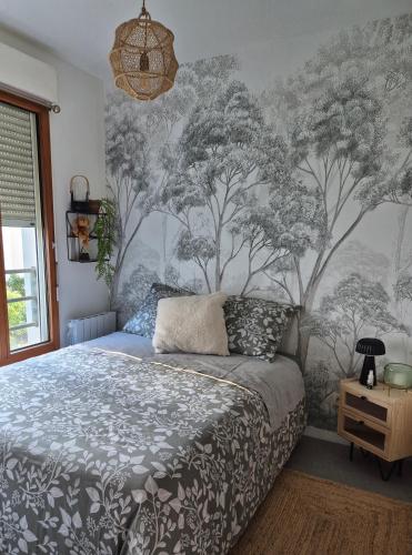 a bedroom with a bed and a wall with trees at Villa Sévigné in Nantes