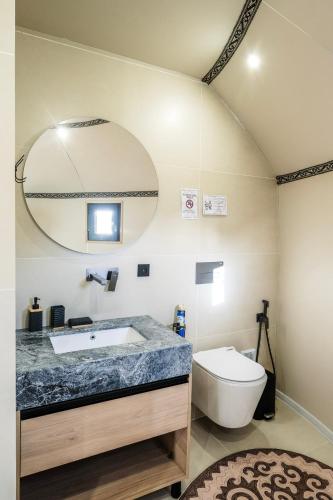 a bathroom with a sink and a toilet and a mirror at Ak-Sai Travel Oimo-Tash Yurt Camp in Kaji-Say