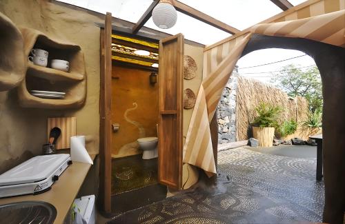 a bathroom with a toilet and an open door at Studio Mazo La Cuevita in Mazo