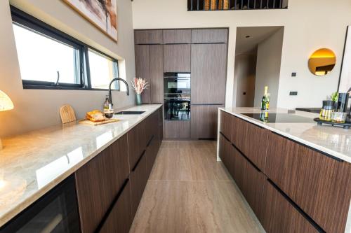 a kitchen with wooden cabinets and a large kitchen island at Modern Aurora Retreat in Selfoss