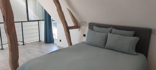 a bedroom with a bed and a large window at La Dépendance d'En Face in Huppy