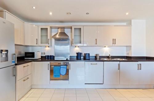 a kitchen with white cabinets and a sink at Bright 2-BDR Apartment - Prime Central Location - Free Wi-Fi in Birmingham