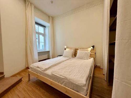 a bedroom with a large bed with a window at Zema11 Old Town Space in Vilnius