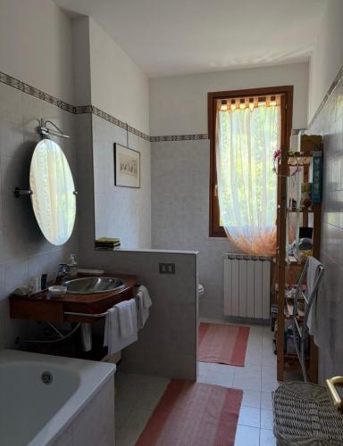 a bathroom with a sink and a tub and a window at CASA DI ALICE a Sambuca Val di Pesa in Badia A Passignano