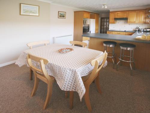 a kitchen with a table and chairs and a kitchen with a counter at Kildonan in Laide