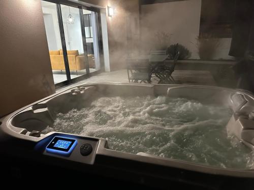 a bath tub filled with water with a thermometer in it at Les mouettes, SPA privé, 600m de la plage, Formule tout inclus in Erdeven