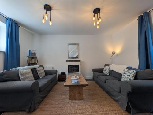 a living room with two couches and a coffee table at An Mor Haven in Coverack