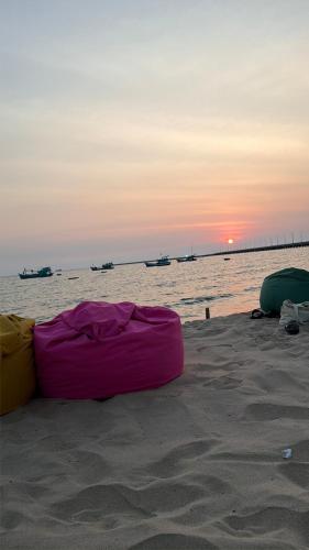 a mattress on the beach with the sunset in the background at Libra House Phu Quoc in Phú Quốc