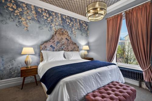 a bedroom with a bed with a blue and white patterned wall at Clarence House in Derry Londonderry