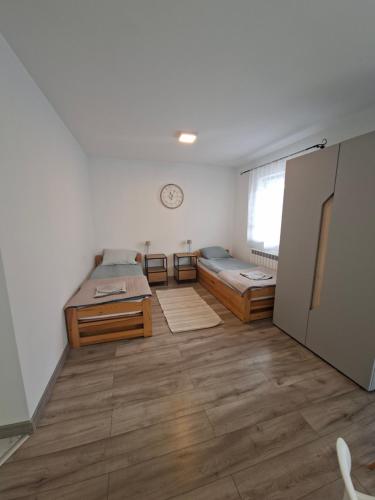 a room with two beds and a clock on the wall at Dom w dolinie in Zagórz
