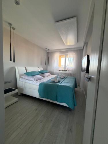 a bedroom with a large bed with blue pillows at Apartament Wczasowa 3 in Sarbinowo