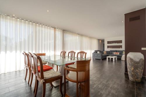 a dining room with a glass table and chairs at Marianas in Bom Sucesso