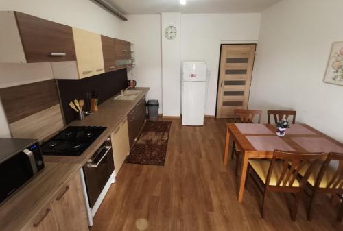a kitchen with a table and a dining room at Privat Teo Podtureň in Liptovský Mikuláš