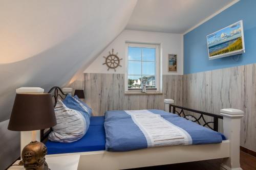 a bedroom with a bed and a window at Strandhaus zum Lotsenturm in Thiessow