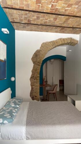 a bedroom with a bed and a stone wall at Barbarossa Sea Room in Termoli